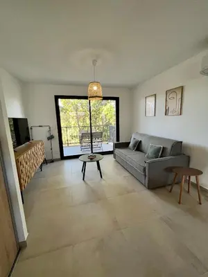 Coin salon dans l'établissement Appartement climatisé neuf au calme, proche centre-ville, 4 minutes en voiture plage et commerces
