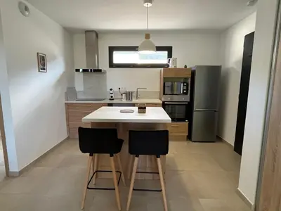 Cuisine ou kitchenette dans l'établissement Appartement climatisé neuf au calme, proche centre-ville, 4 minutes en voiture plage et commerces