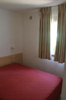 Un ou plusieurs lits dans un hébergement de l'établissement Trilocale in residence con piscina a 200 m dal mare