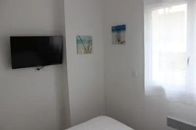 Télévision ou salle de divertissement dans l'établissement T3 vue mer direct plage clim N79
