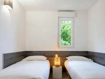 Un ou plusieurs lits dans un hébergement de l'établissement Apartment MB4 piscine by Interhome