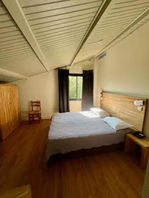 Un ou plusieurs lits dans un hébergement de l'établissement Logis Hotel Le Lonca