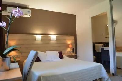Un ou plusieurs lits dans un hébergement de l'établissement Hôtel le Grillon