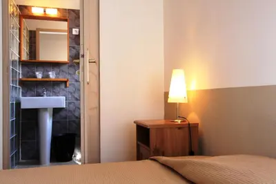 Un ou plusieurs lits dans un hébergement de l'établissement Hôtel et Résidence Benista