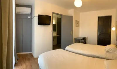 Un ou plusieurs lits dans un hébergement de l'établissement Hôtel les Arbousiers
