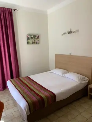 Un ou plusieurs lits dans un hébergement de l'établissement Hôtel Colombo- Porto Corse