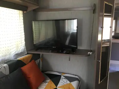 Télévision ou salle de divertissement dans l'établissement La Caravane LE NID DOUILLET