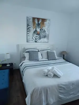 Un ou plusieurs lits dans un hébergement de l'établissement maison cosy climatisée avec piscine et jardin