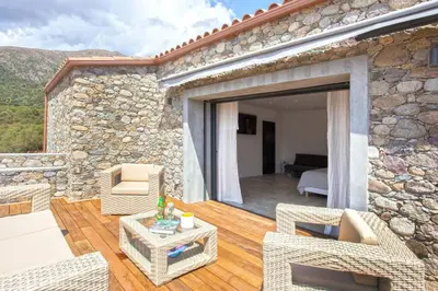 Coin salon dans l'établissement Maison en pierre Corse avec vue proche des Gorges de l'Asco entre mer montagne et piscine