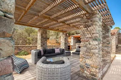 Coin salon dans l'établissement Maison en pierre Corse avec vue proche des Gorges de l'Asco entre mer montagne et piscine