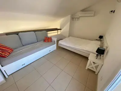Un ou plusieurs lits dans un hébergement de l'établissement Ma paillote a LOZARI 6/8 pers vue mer avec piscine